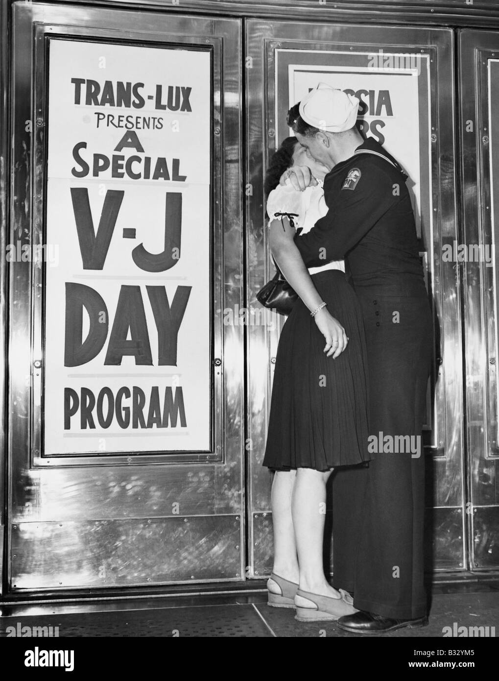 U.S. sailor and his girlfriend celebrate news end war Japan in front Trans-Lux Theatre in New York's Time Square August 14, 1945 Stock Photo
