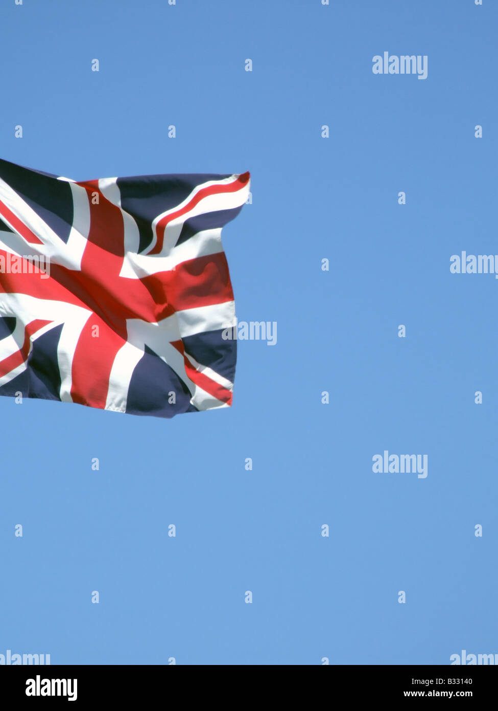 union jack british flag flying high in blue sky Stock Photo - Alamy