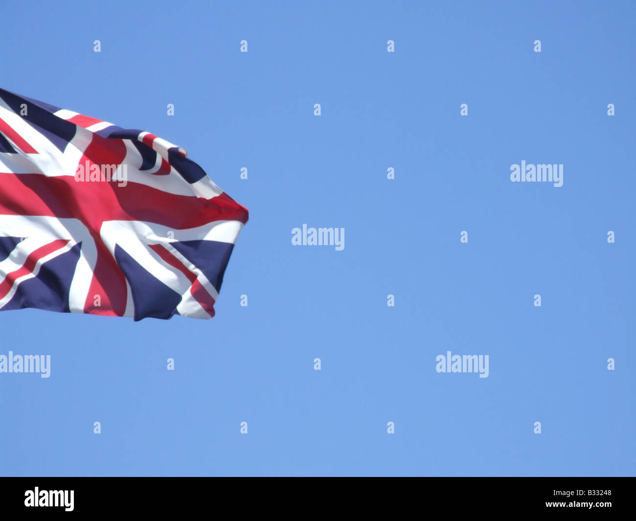 union jack british flag flying high in blue sky Stock Photo - Alamy