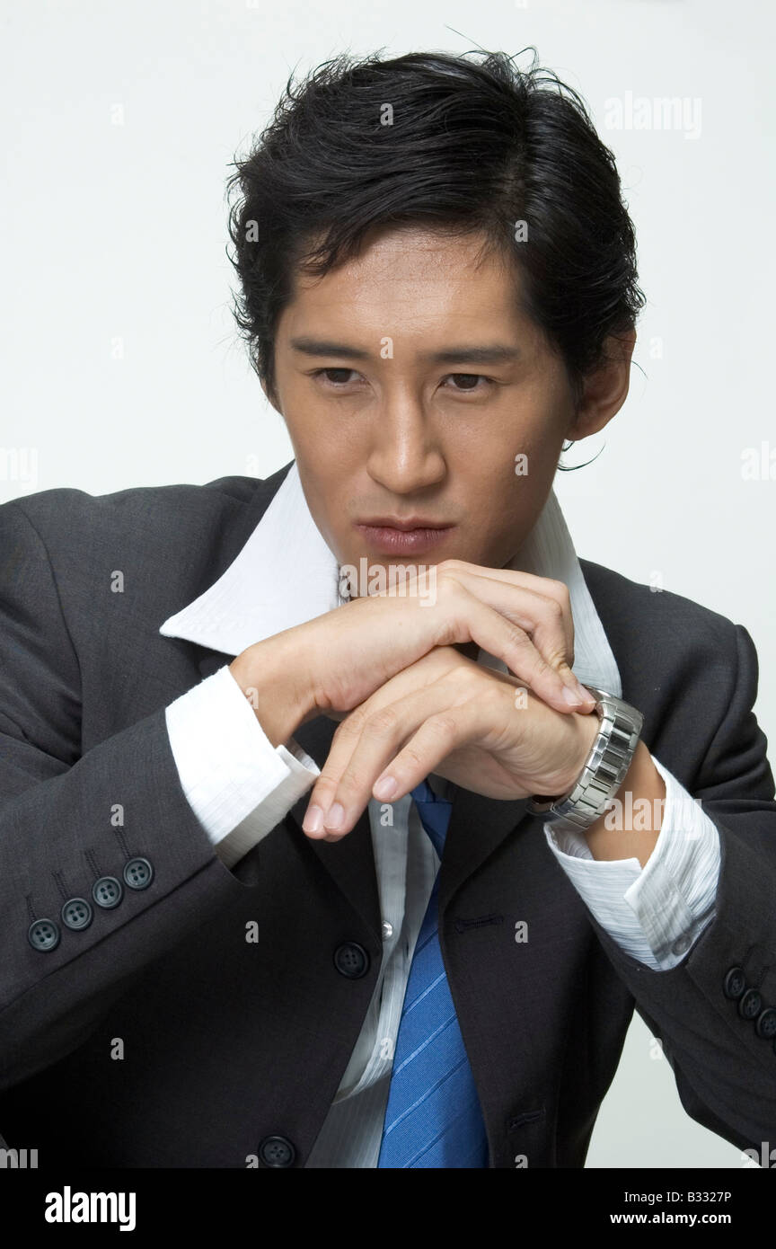 An asian businessman looks serious as he thinks Stock Photo