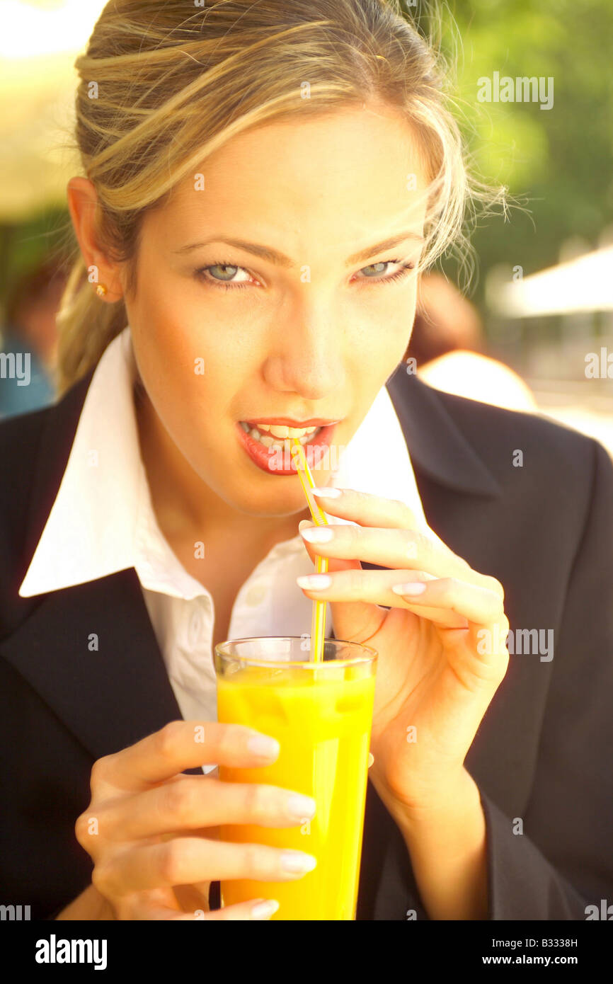 businesswoman drinking orange juice in a bistro, portrait Stock Photo
