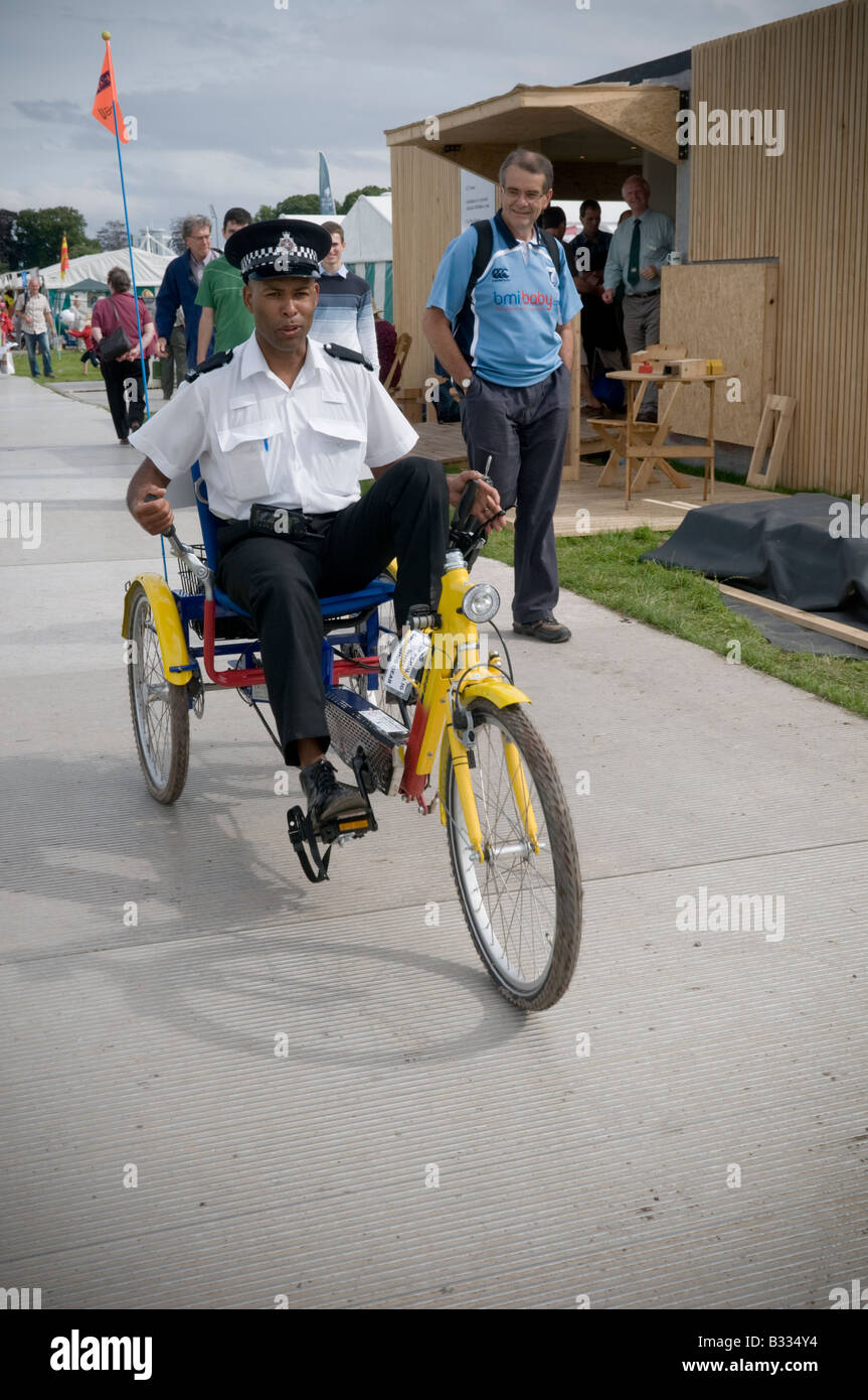 Black policeman pedalling tricycle at the National Eisteddfod of Wales Cardiff August 2008 - annual welsh cultural festival Stock Photo