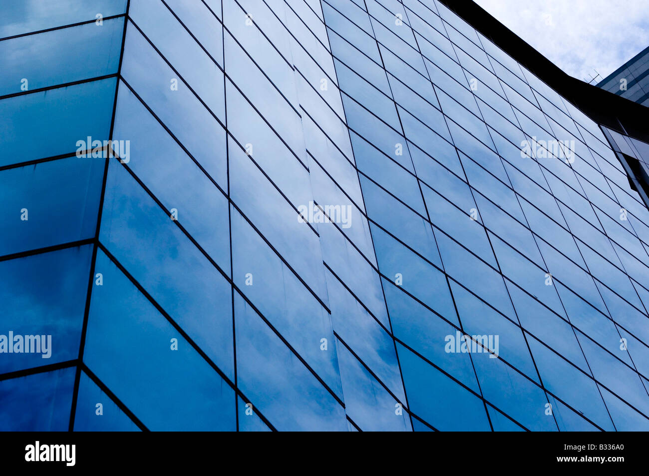 The blue sky is reflected in the glass of an office building Stock ...