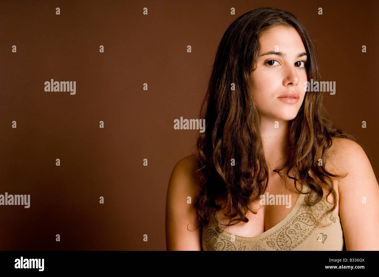 A naturally beautiful young woman on a brown background Stock Photo - Alamy