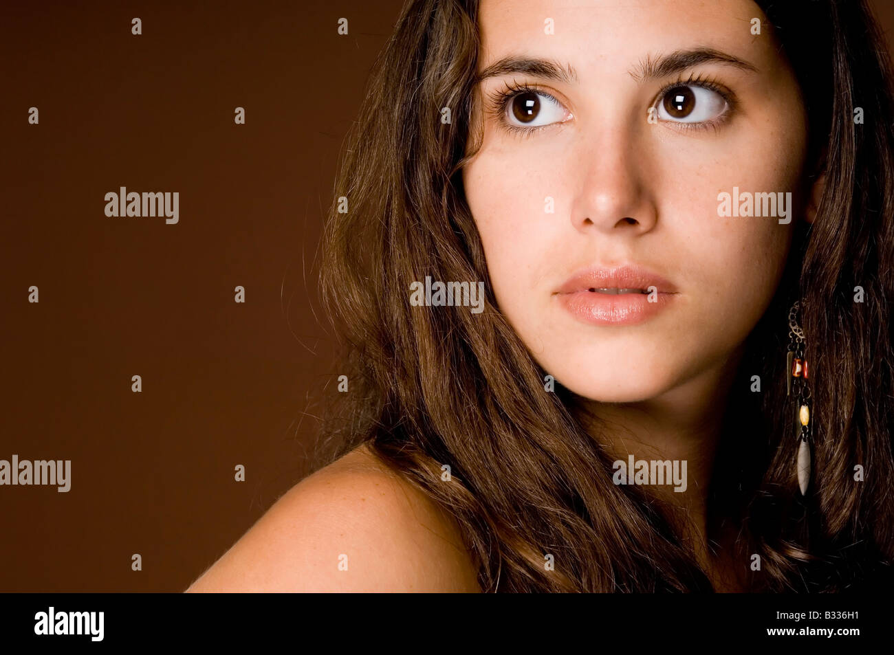 A naturally beautiful young woman on a brown background Stock Photo - Alamy