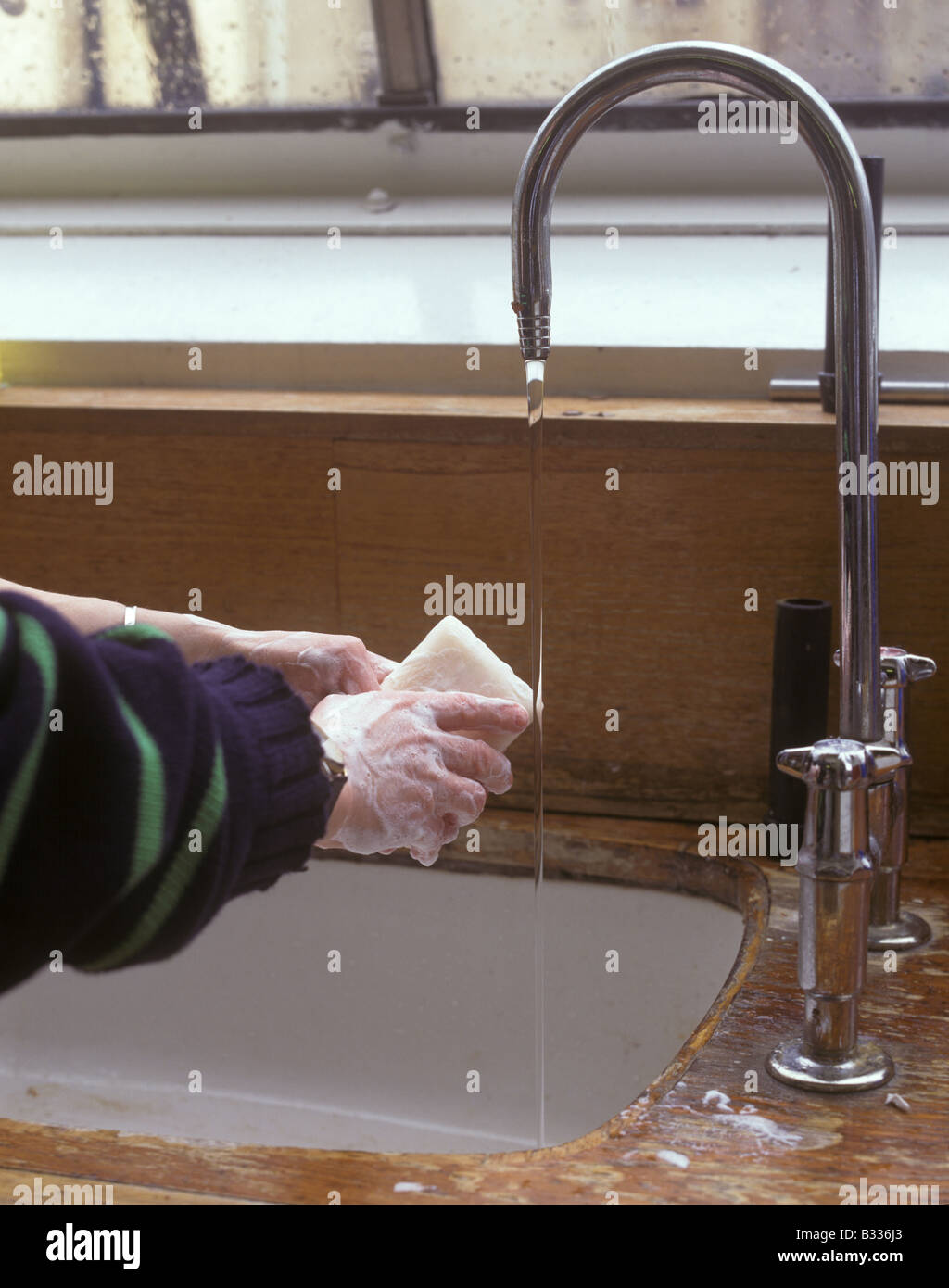 Technician uses soap to wash hands in laboratory Stock Photo