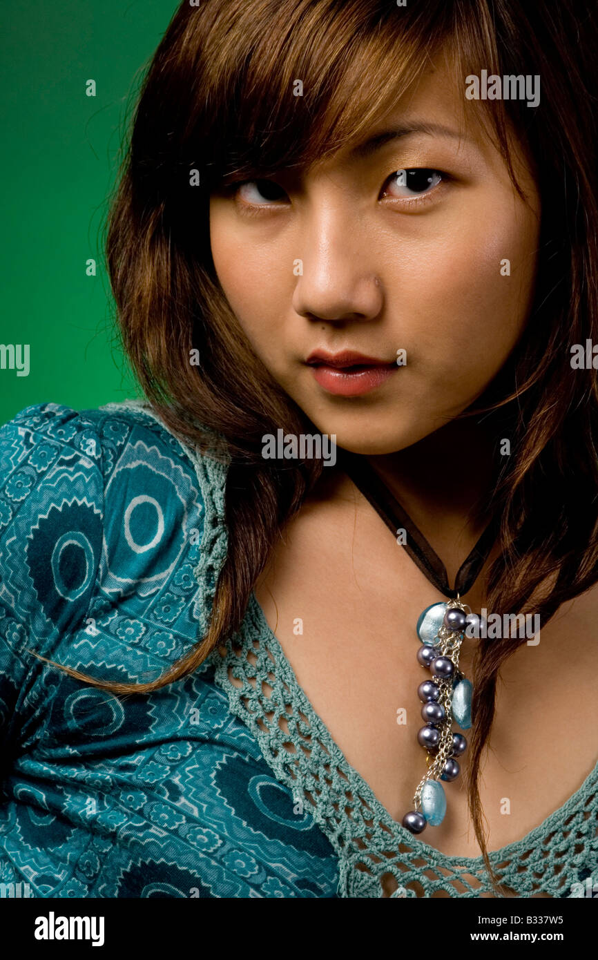 A pretty young asian model in blue dress on green background Stock ...