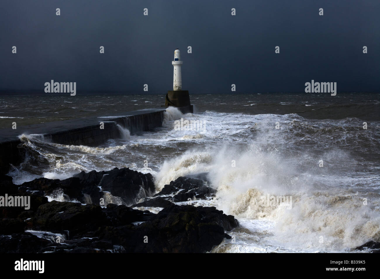Severe weather battering one of the lighthouses marking the entrance to Aberdeen Harbour, Aberdeenshire, Scotland Stock Photo
