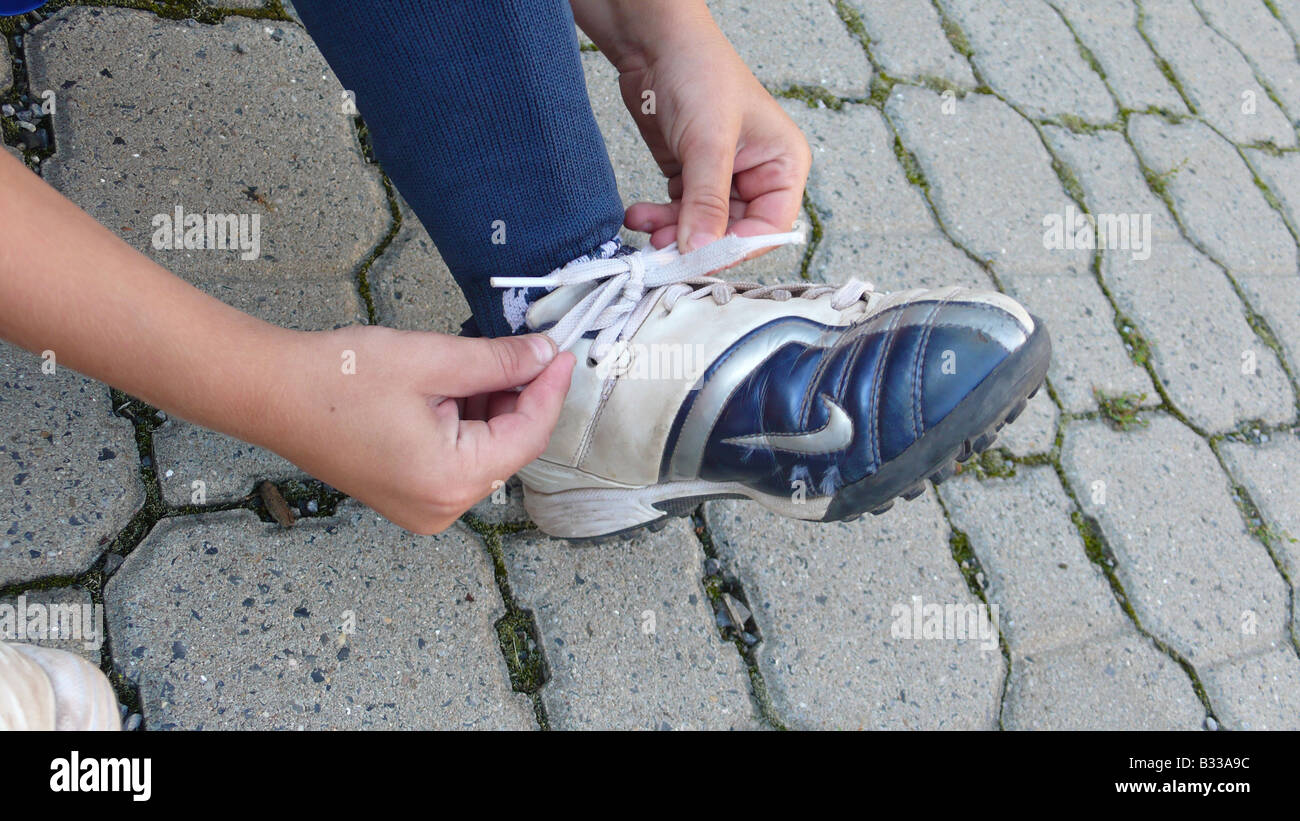 boy tying his football shoes, series picture 5/6 Stock Photo