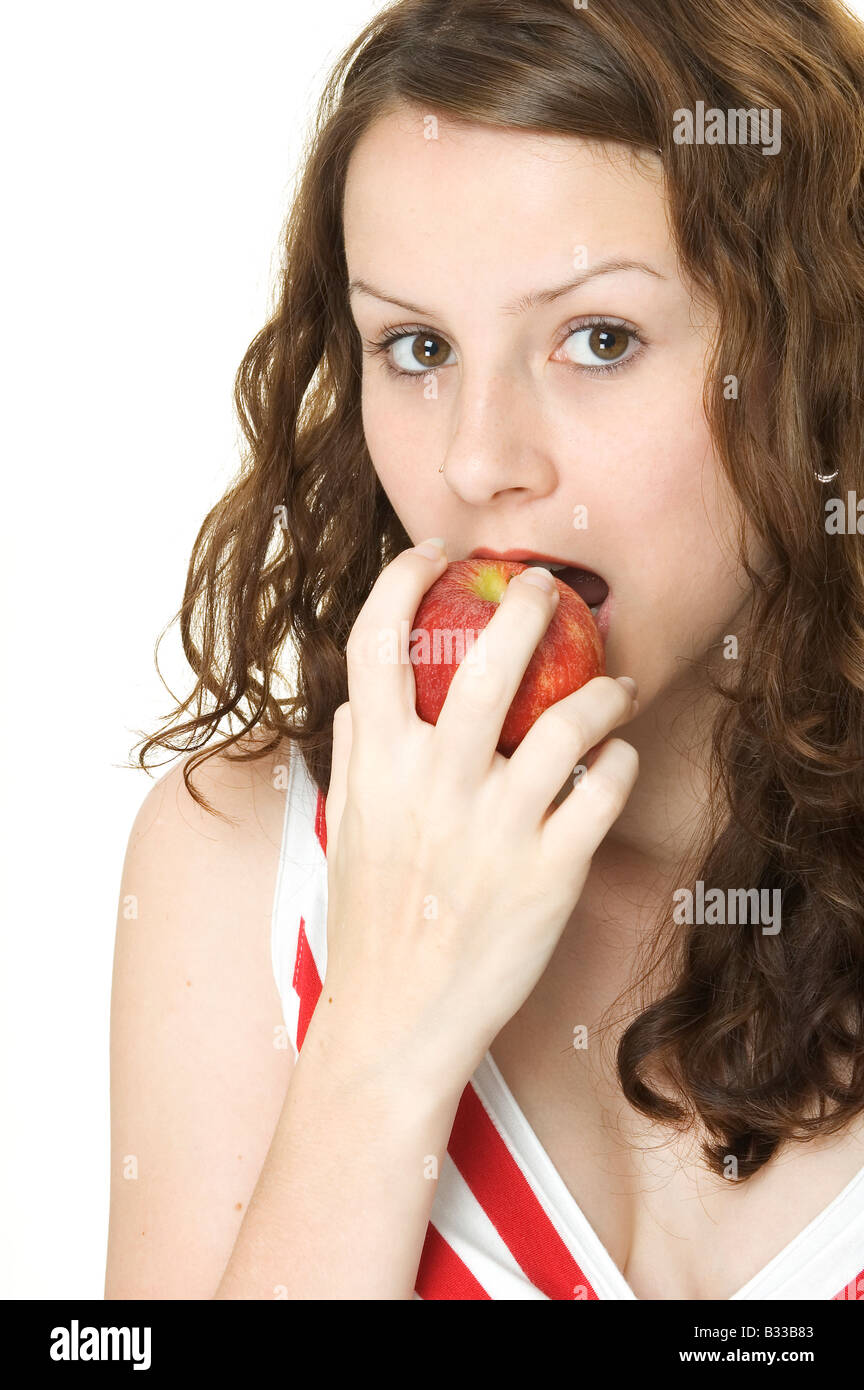 A young woman eats a red apple Stock Photo