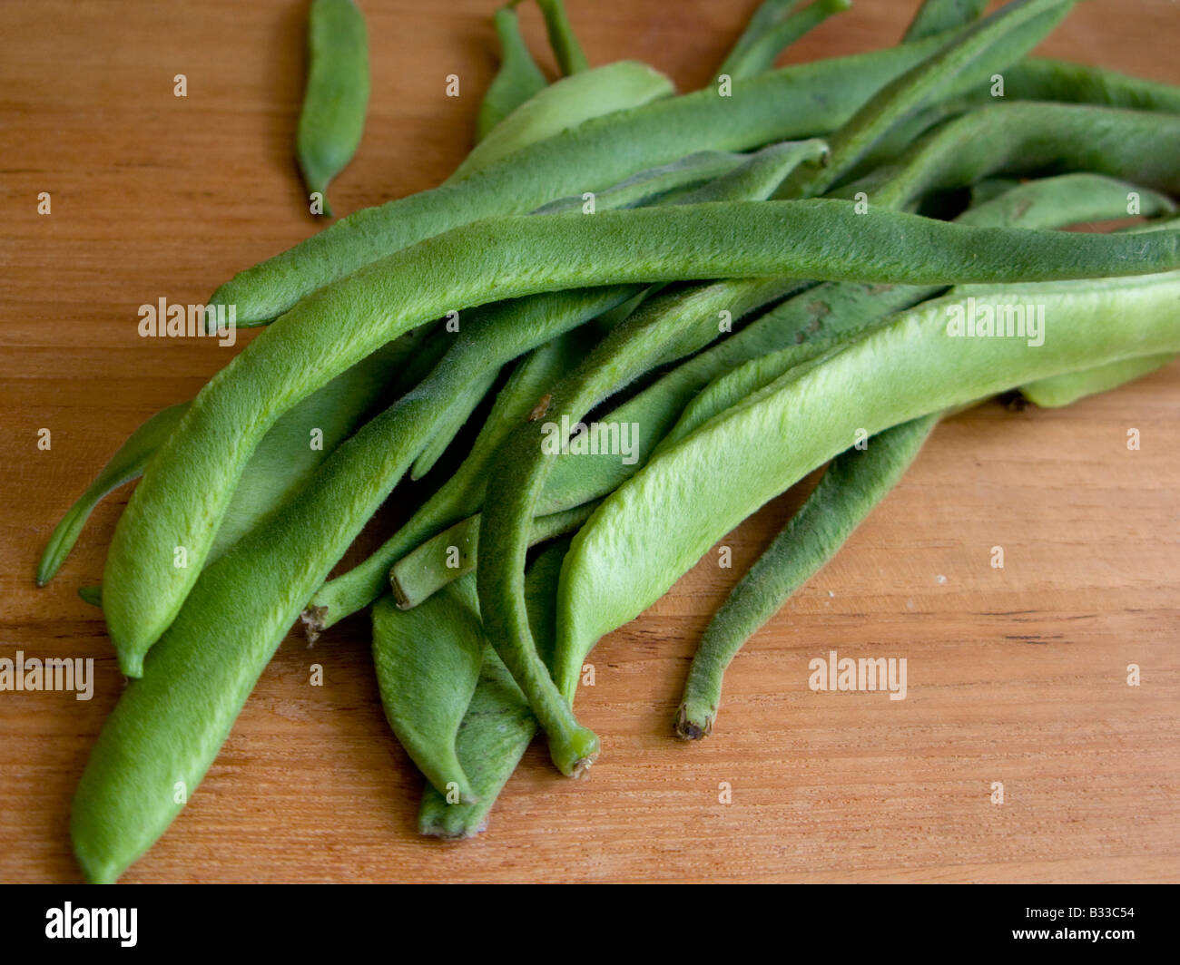 Home grown fresh runner beans on a wooden chopping board Stock Photo