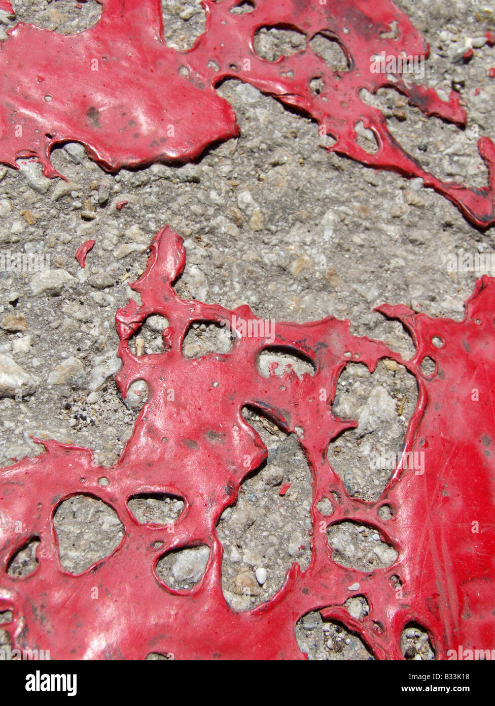 flaking red paint on old road surface Stock Photo