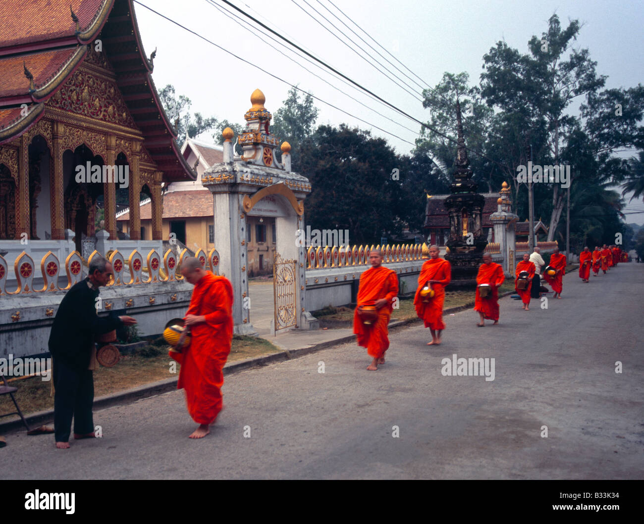 Laos Luang Prabang Morningalms Long row of monks on daily alms in front of Wat Sop Stock Photo