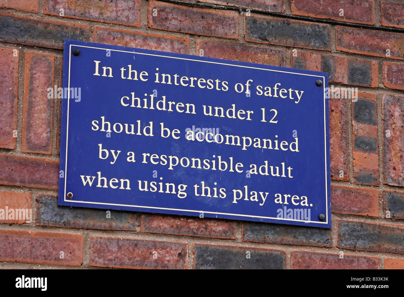 Sign on playground wall setting out the rules of use for the area and restrictions. Stock Photo