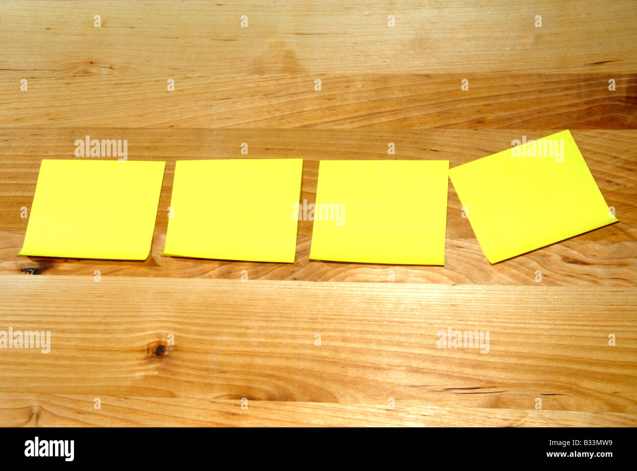 Yellow stickies on wooden board Stock Photo