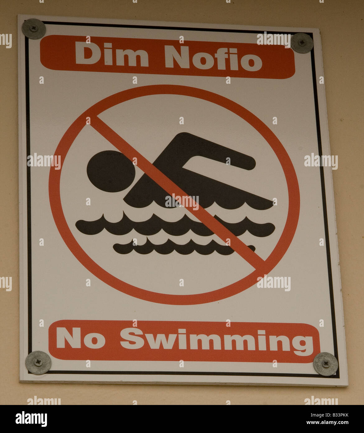 Bi-lingual Welsh/English notice prohibiting swimming in Porthcawl Harbour S Wales Stock Photo