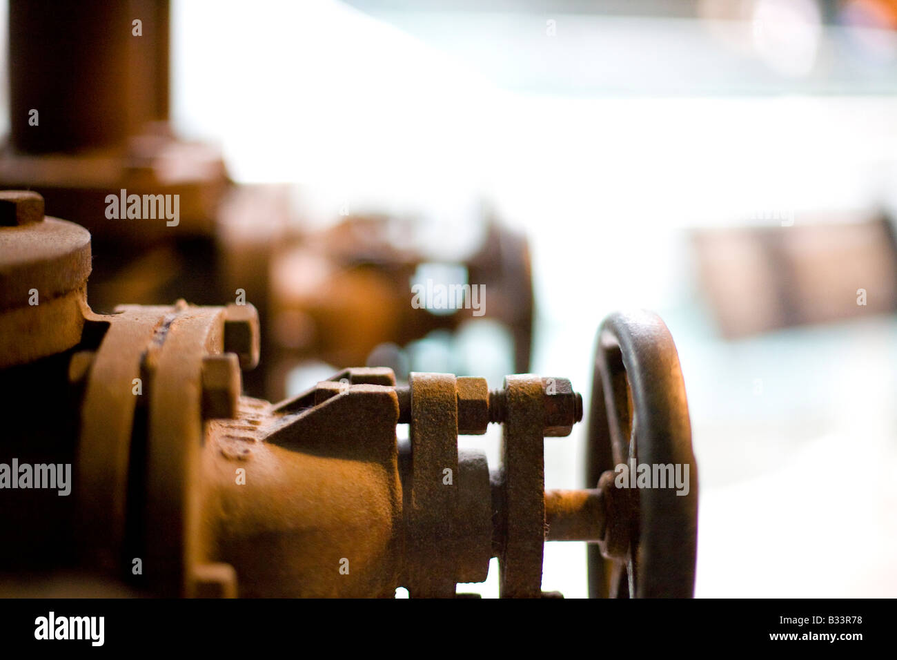 control valves in a disused industrial setting differential focus and backlit Stock Photo