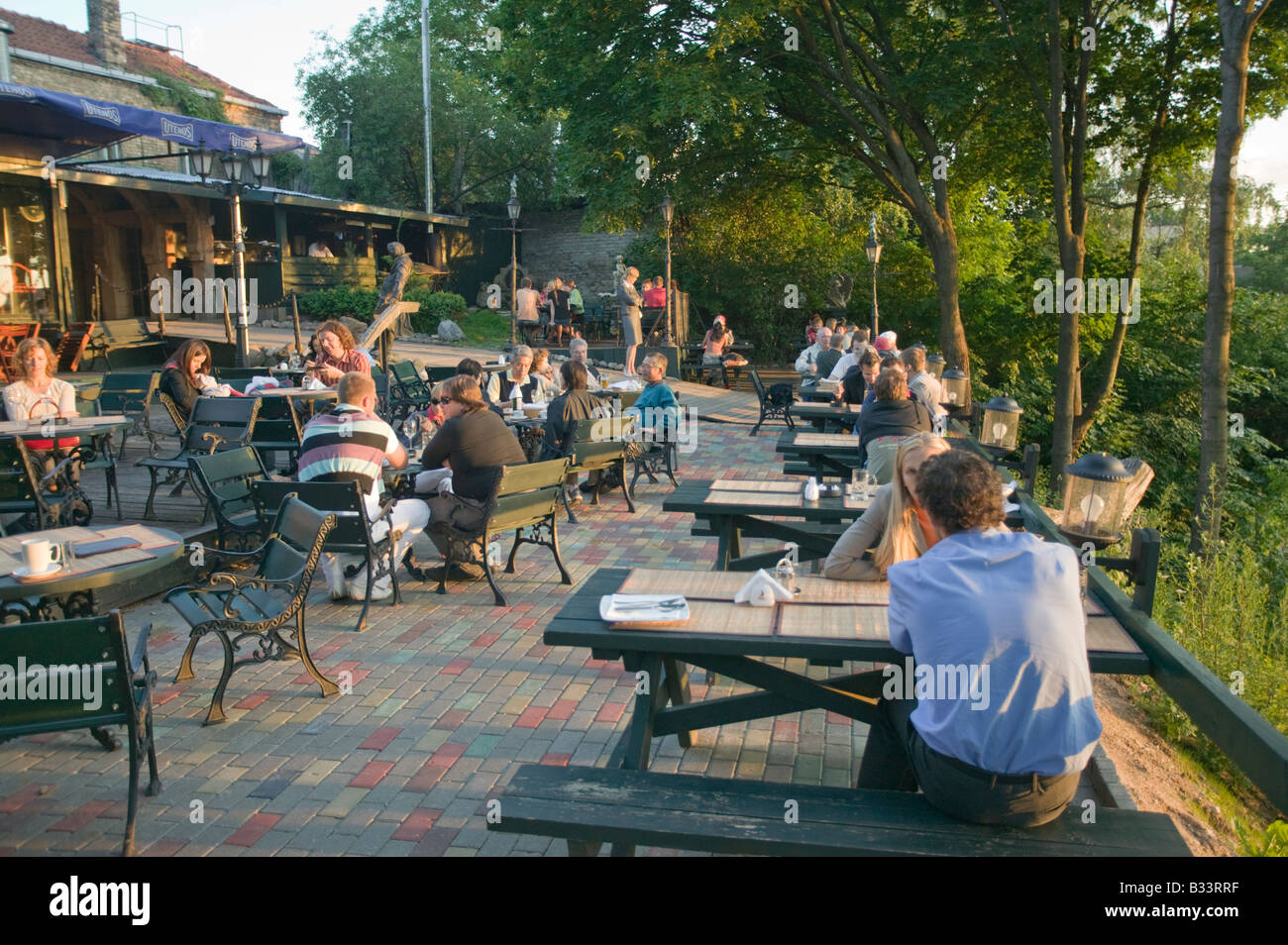 People at the Tores Restaurant bathed in evening sunlight Vilnius Lithuania Stock Photo