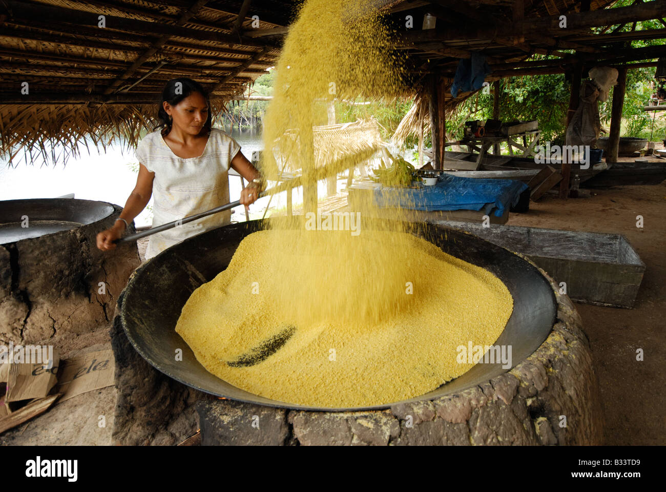 Woman making farinha in the Amazon Stock Photo