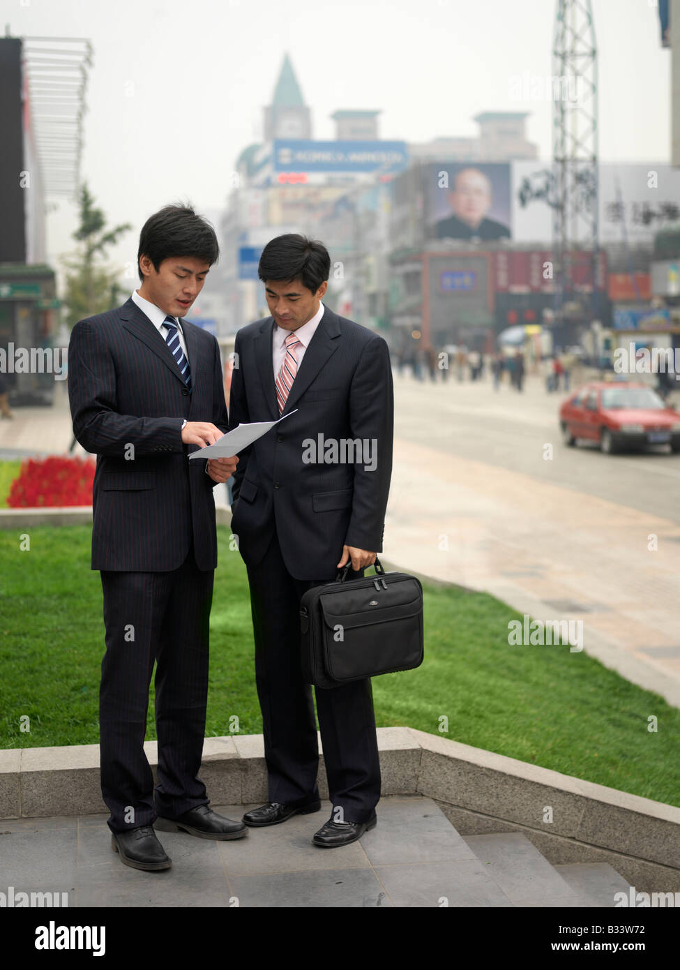 Chinesemen discussing about information on a document. Stock Photo