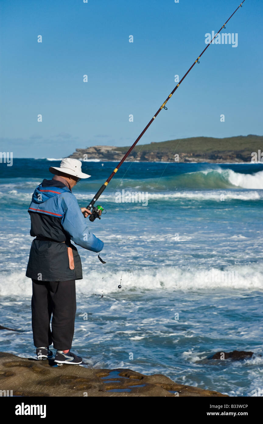 Rock fishing: man fishing in the sea on the rocks Stock Photo - Alamy