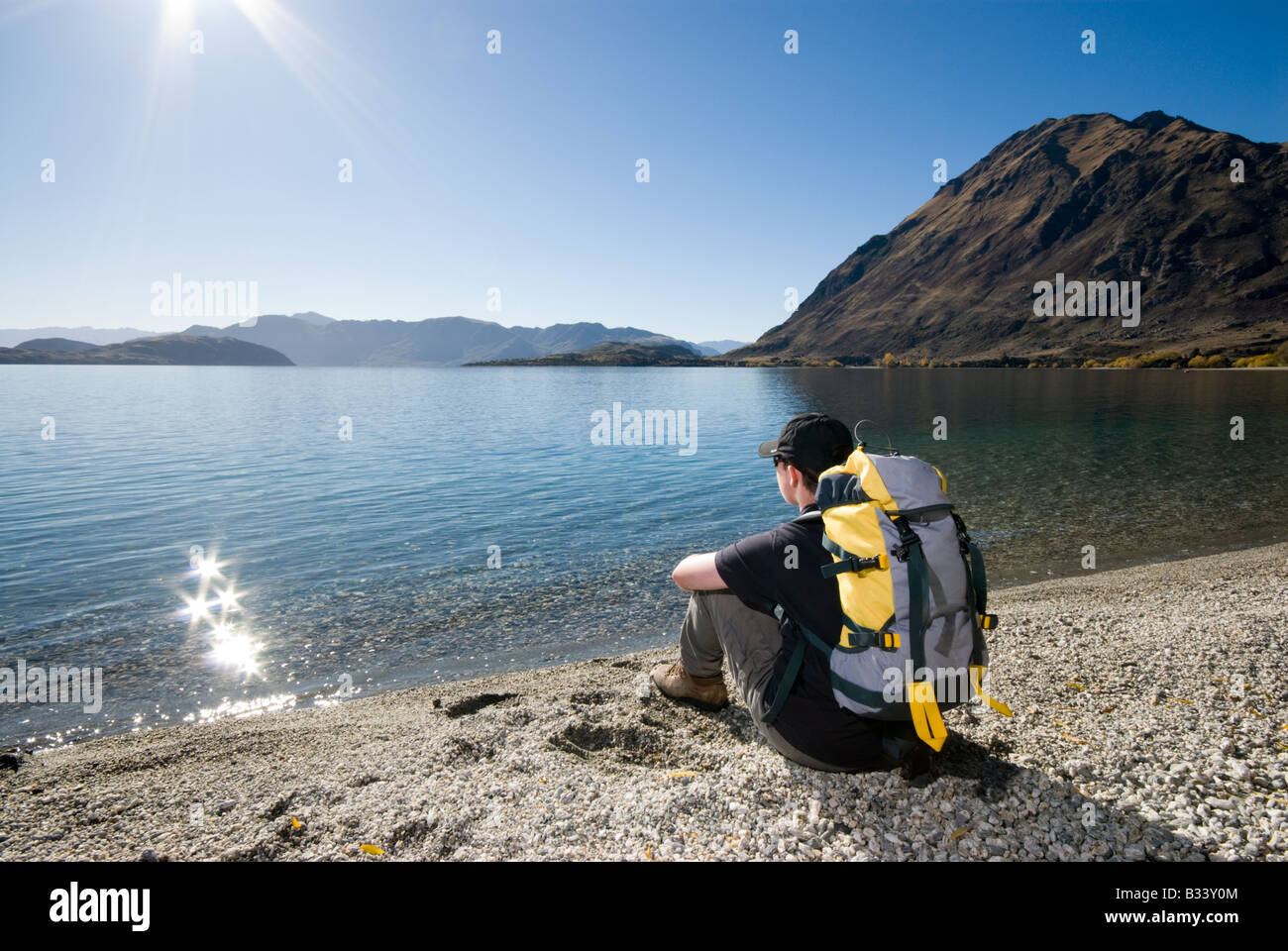 Young hiker sat on the shores of a lake Stock Photo