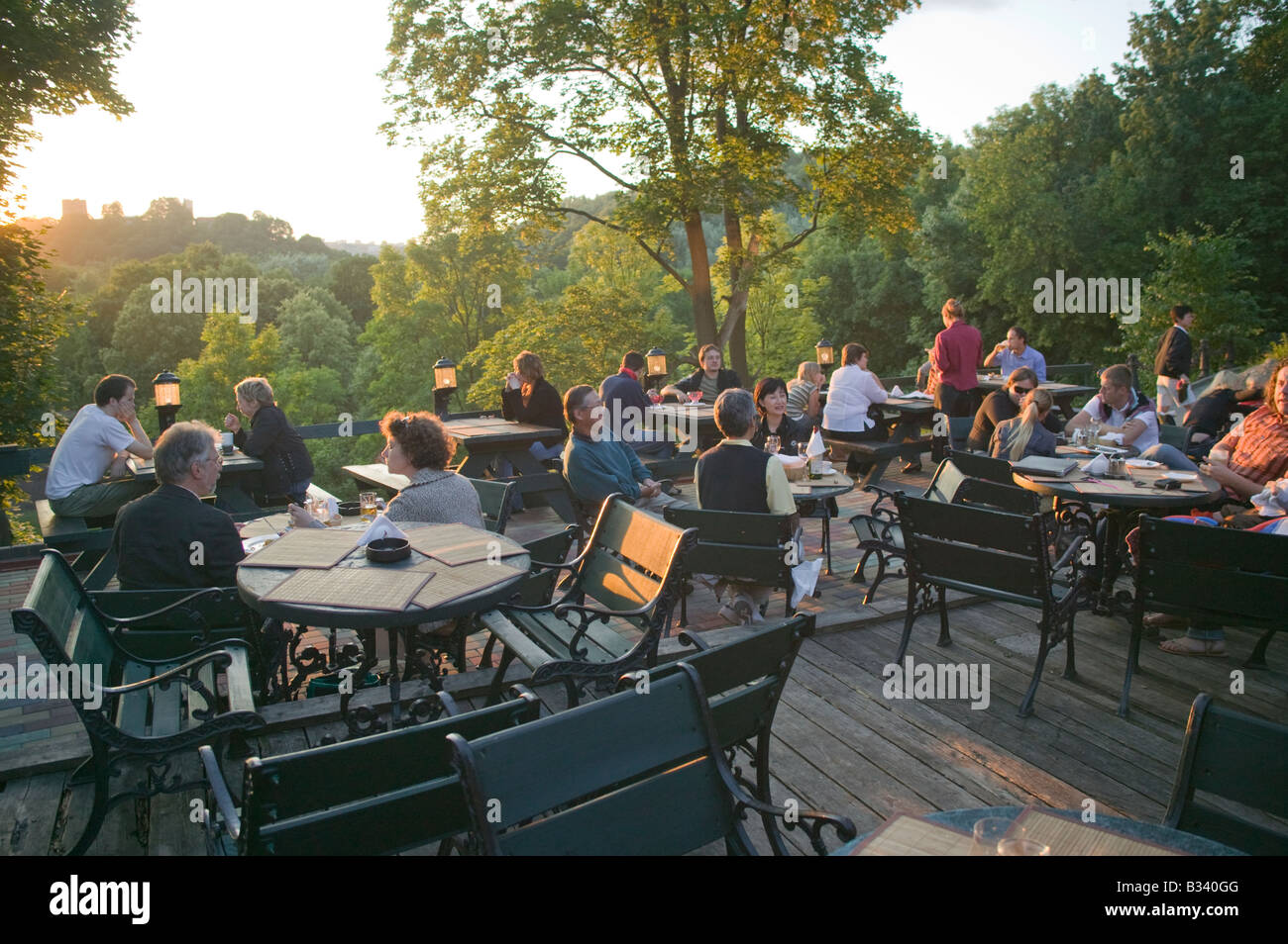 People at the Tores Restaurant bathed in evening sunlight Vilnius Lithuania Stock Photo