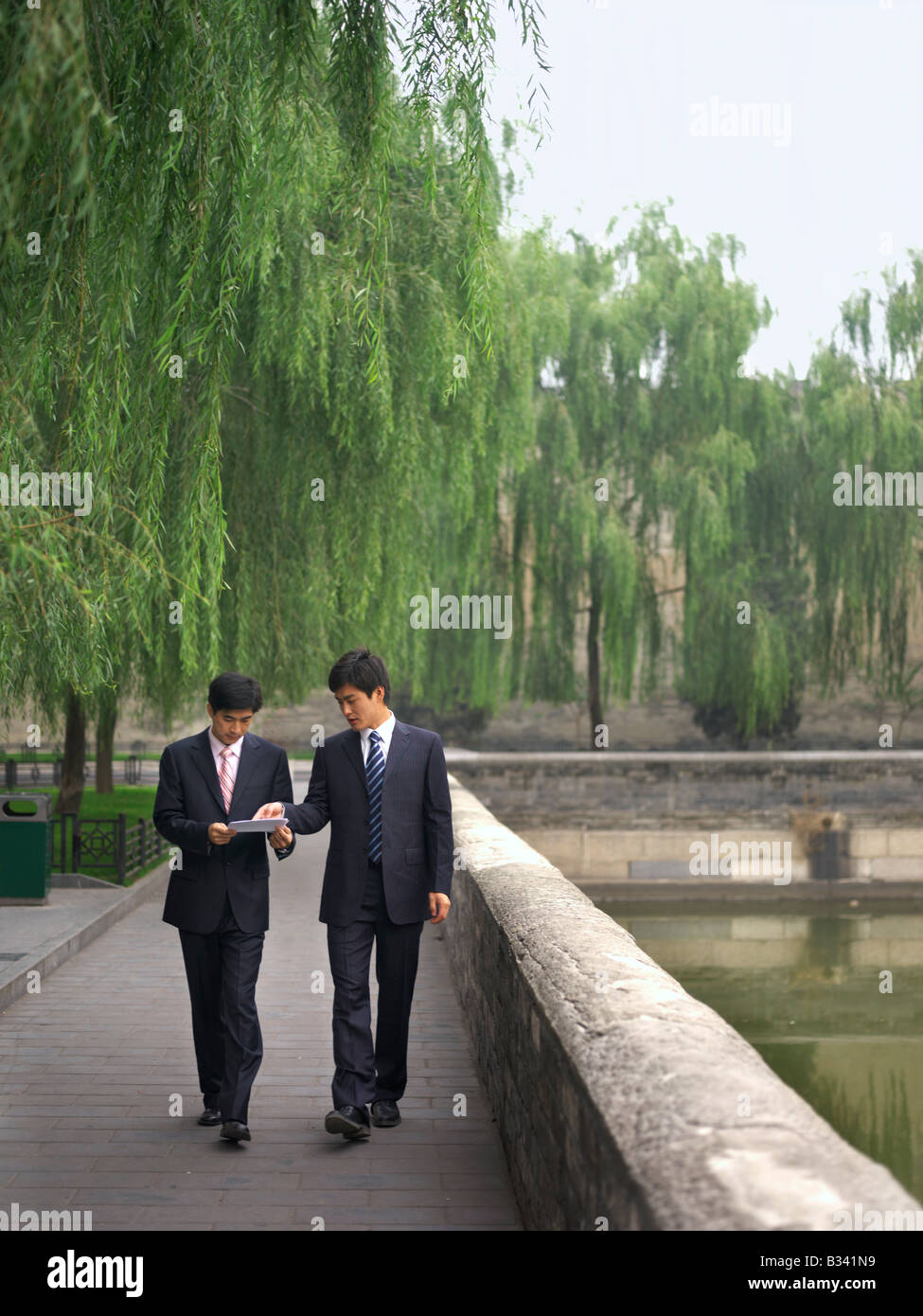 Chinese Businessmen discussing  while looking over a document, Stock Photo