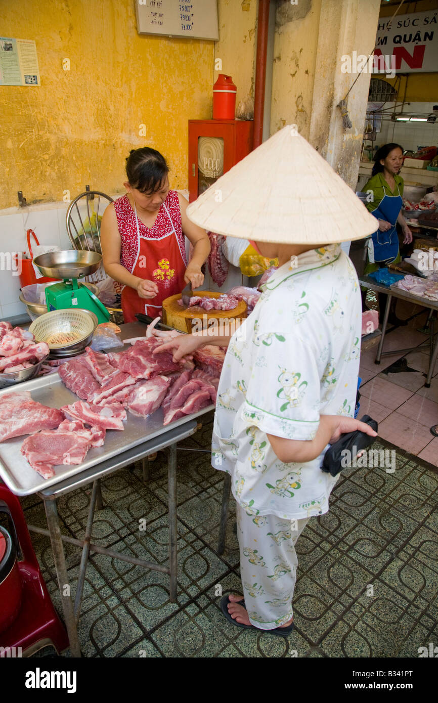 A vietnamese woman shopping for meat at a local market Stock Photo