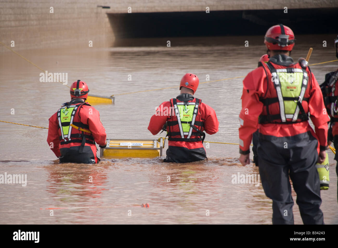 Emergency rescue firemen position submersible pump in floodwater Stock Photo