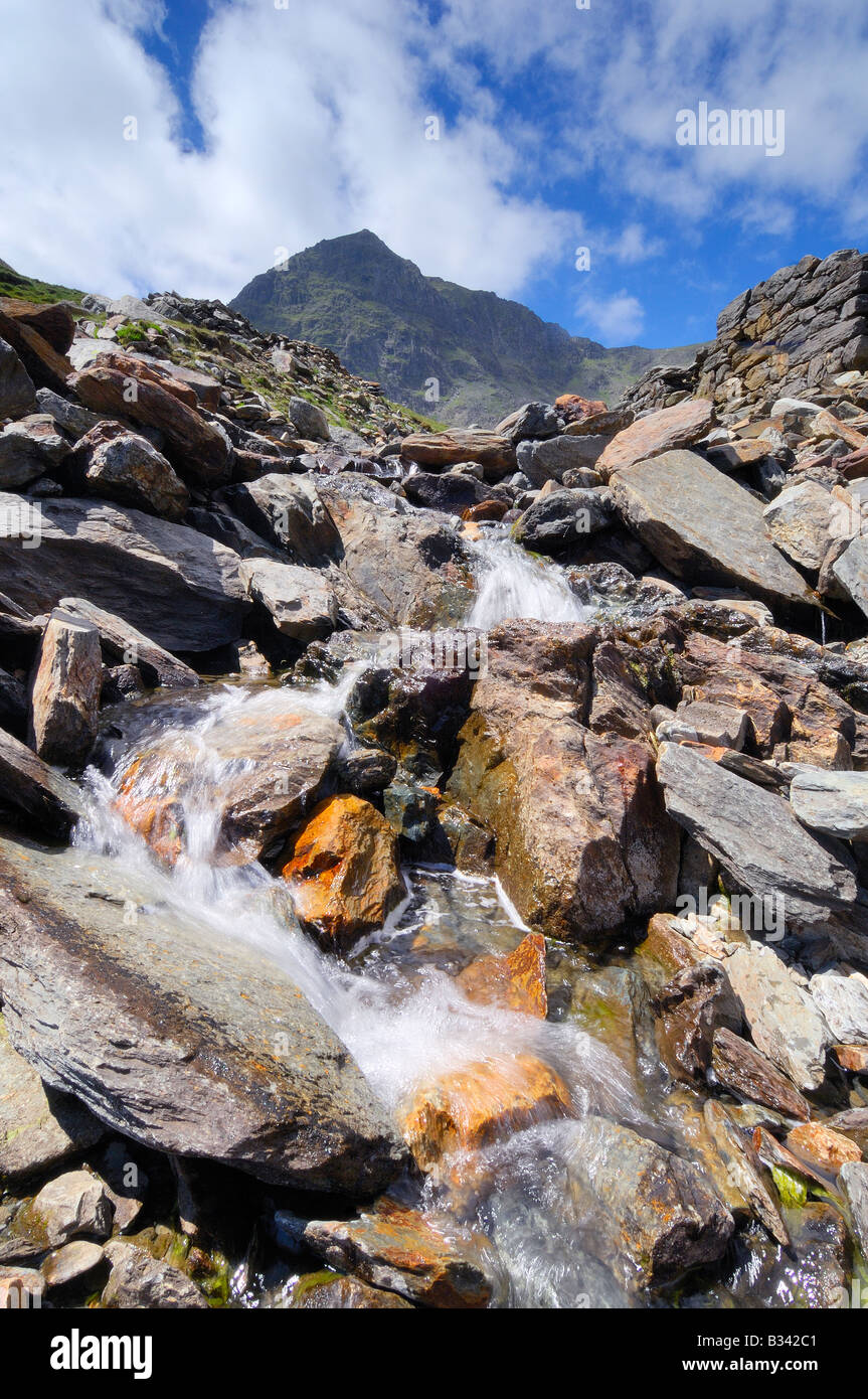 Waterfall flowing between Llyn Glaslyn and Llyn Llydaw beside the Miners Track route to the summit of Mount Snowdon Stock Photo