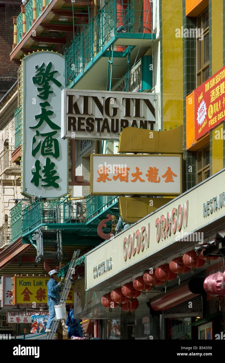 Man on a ladder repairing restaurant signs in the Chinatown district of San Francisco, California, United States of America Stock Photo