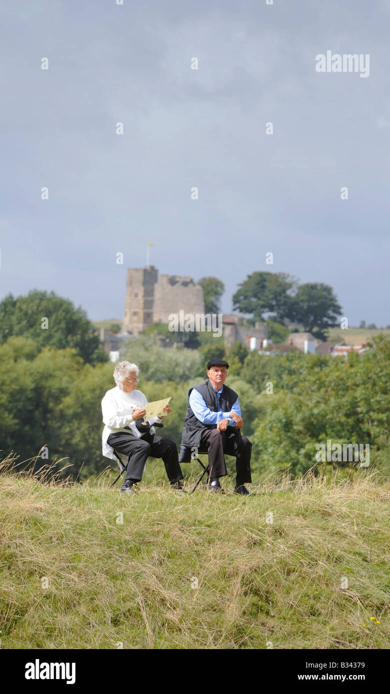 A retired couple sitting on the river bank with Lewes Castle as a backdrop. Picture by Jim Holden Stock Photo