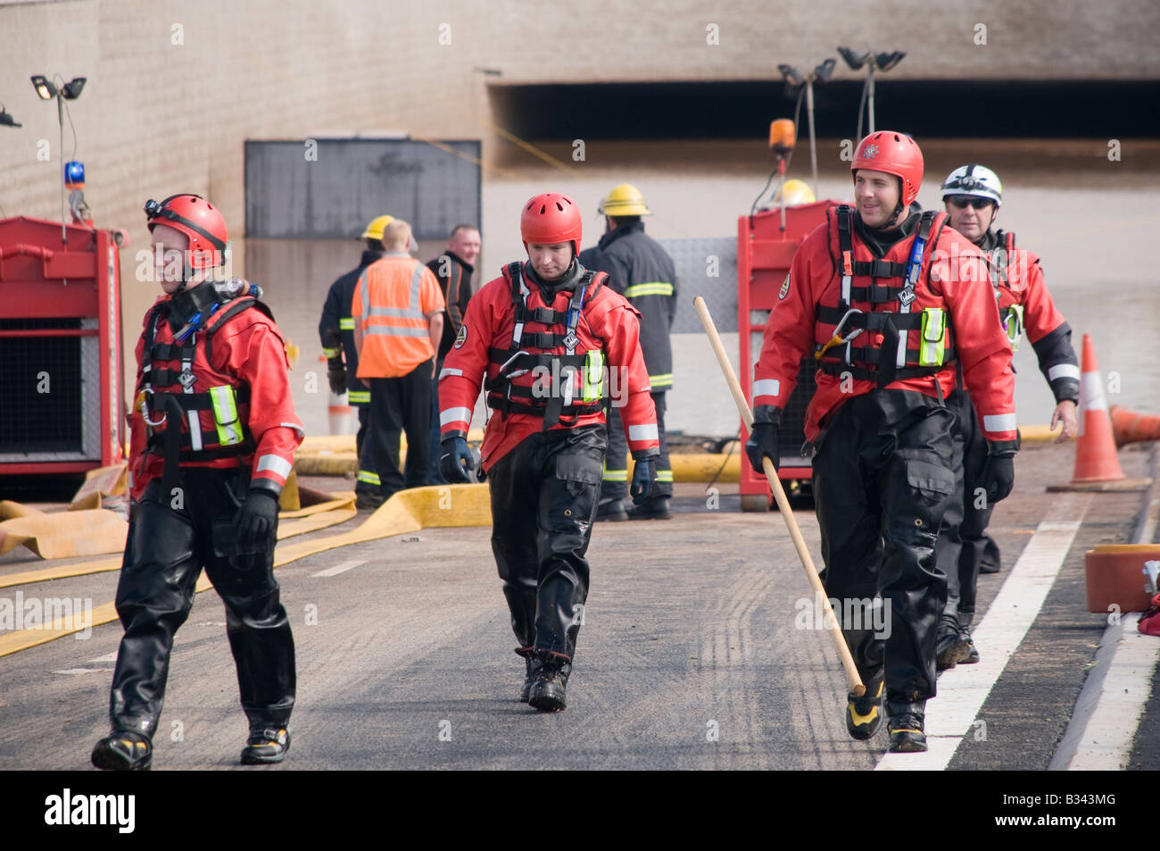 Firemen return from placing submersable pump Stock Photo