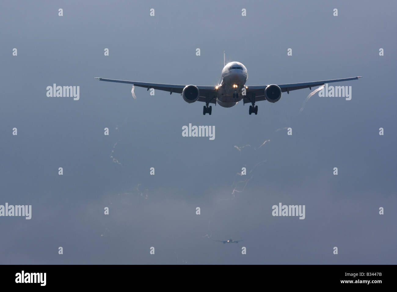 Commercial aeroplane on approach with visible wingtip vortices Stock Photo