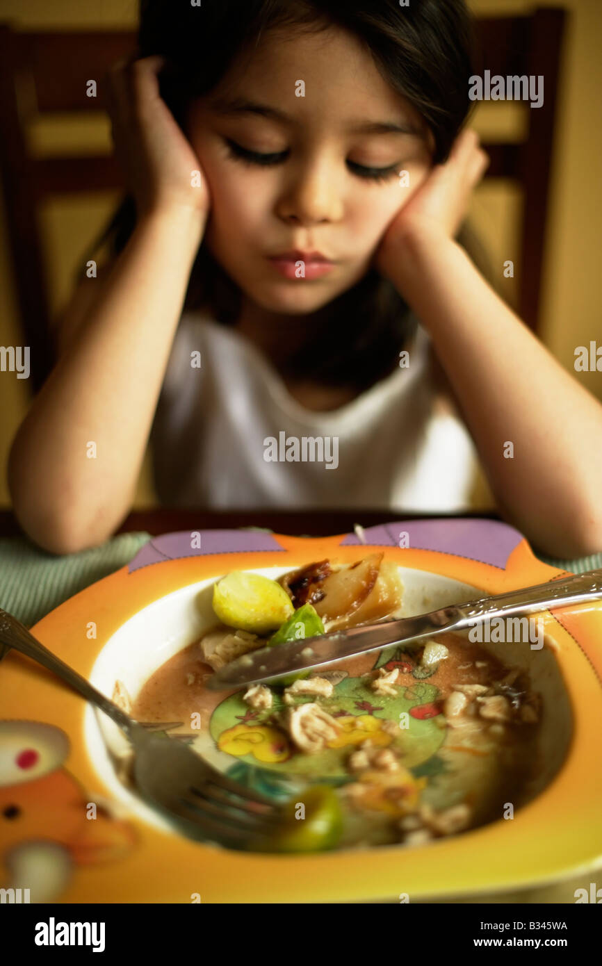 Five year old girl becomes choosey about her food and decides she no longer likes eating Brussel sprouts Stock Photo