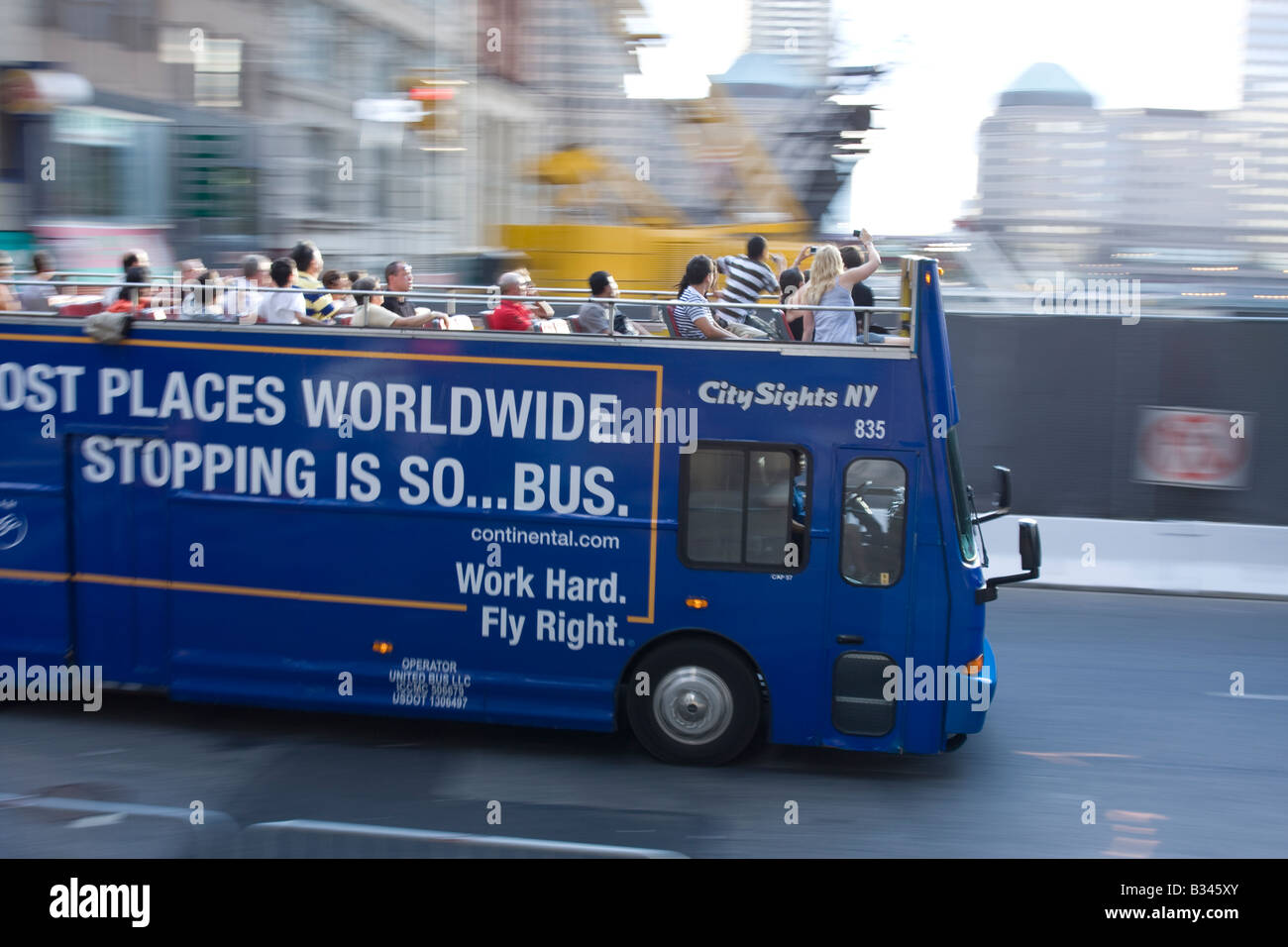 Tourists stand on a City Sights NY tour bus to see over the Ground Zero ...