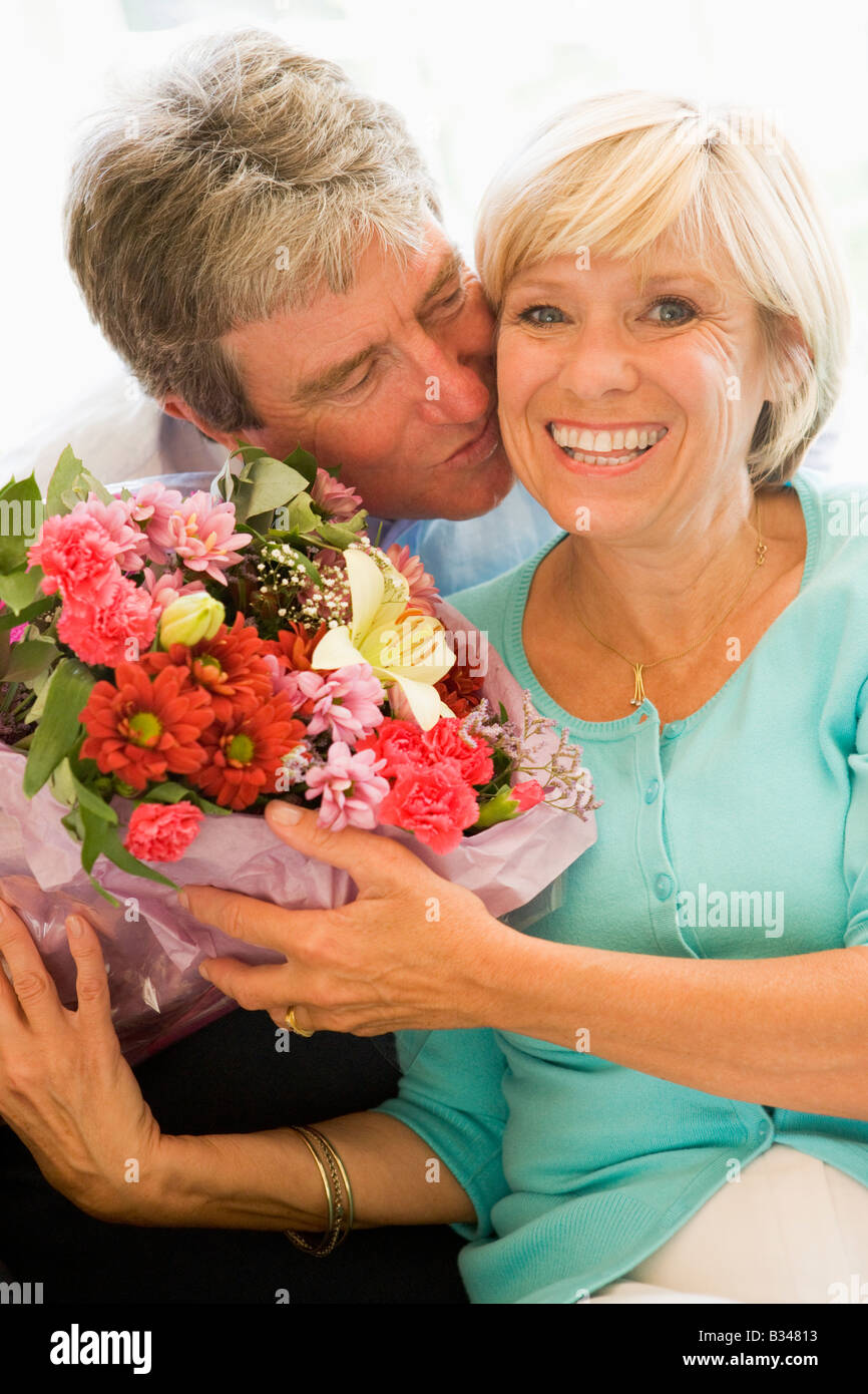 Husband giving wife flowers kissing and smiling Stock Photo Alamy