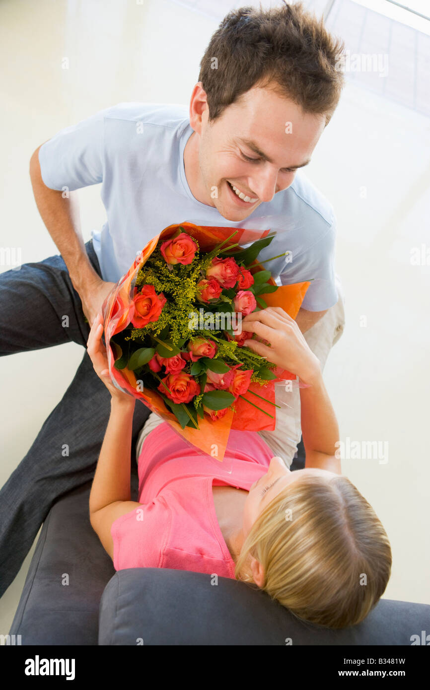 Husband giving wife flowers and smiling Stock Photo