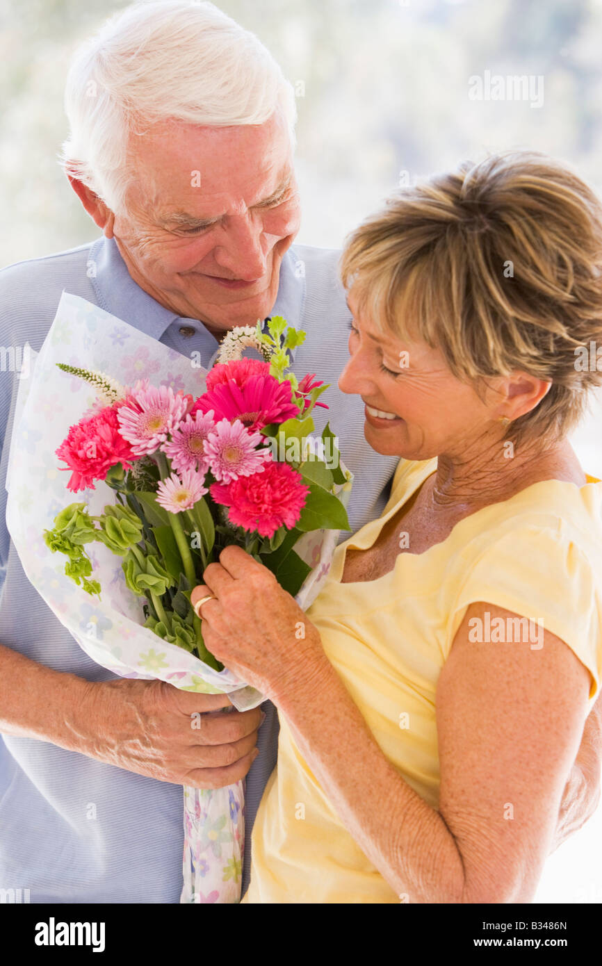 Husband giving wife flowers and smiling Stock Photo Alamy