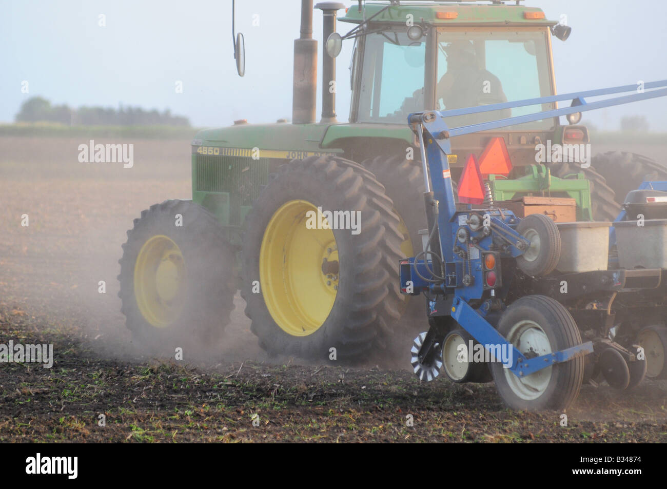 John Deere tractor planting corn or soybeans in an American farm field