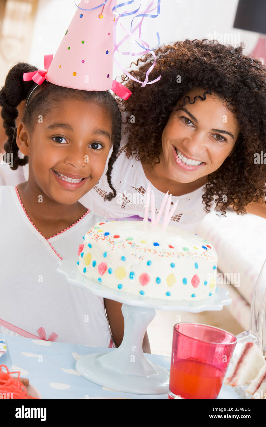 Mother and daughter with birthday cake smiling Stock Photo Alamy