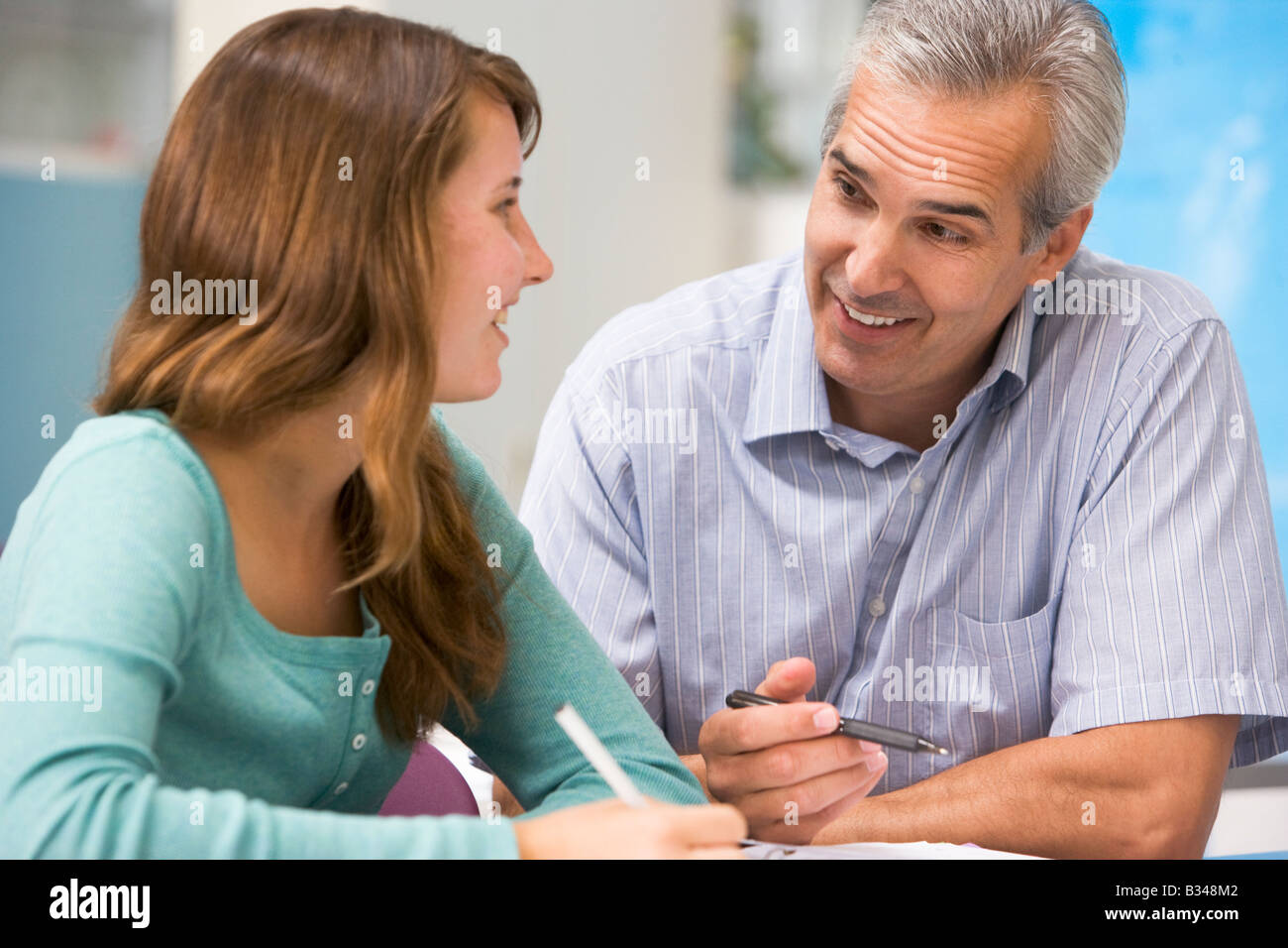 Teacher giving personal instruction to female student Stock Photo Alamy