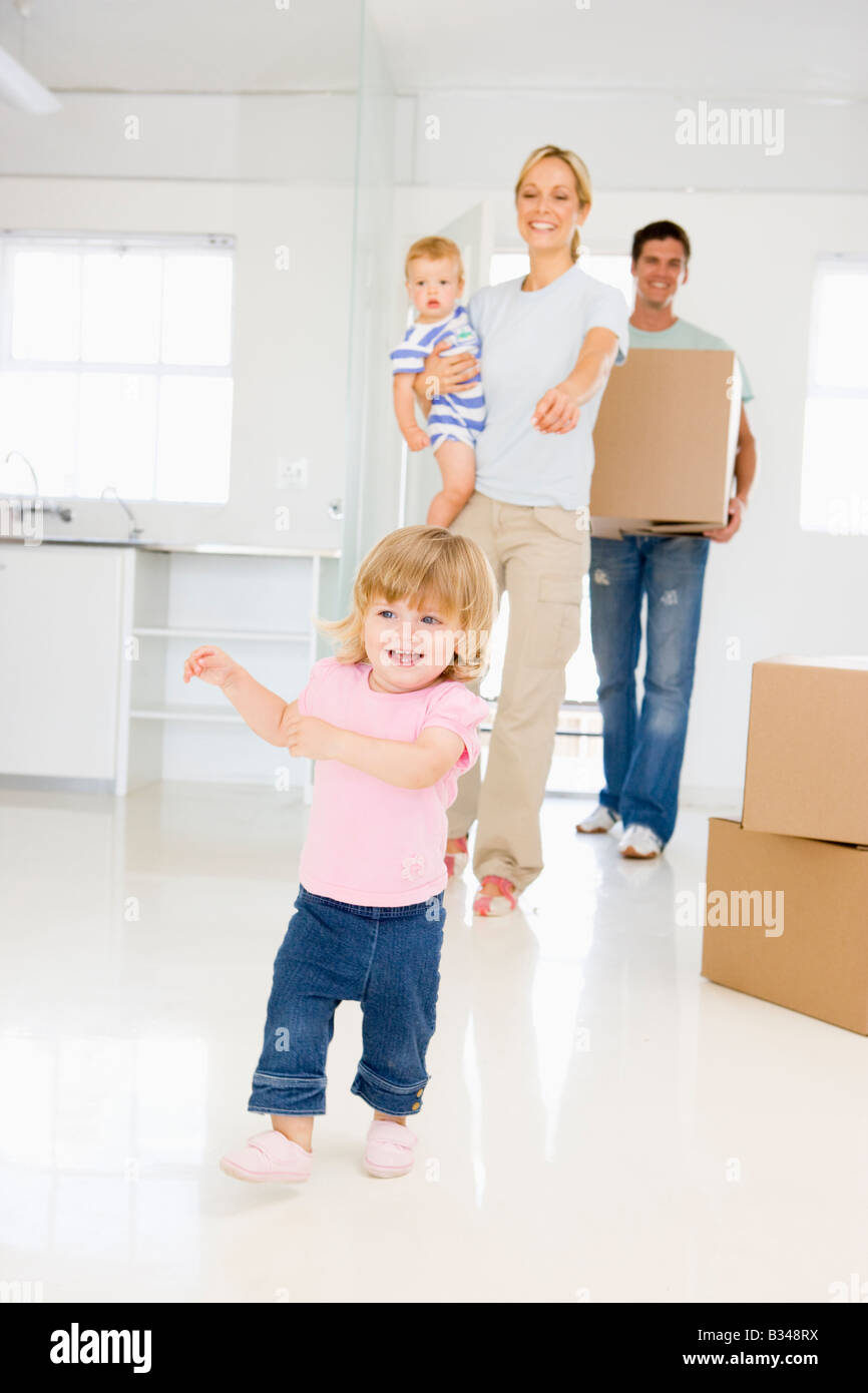 Family with box moving into new home smiling Stock Photo - Alamy