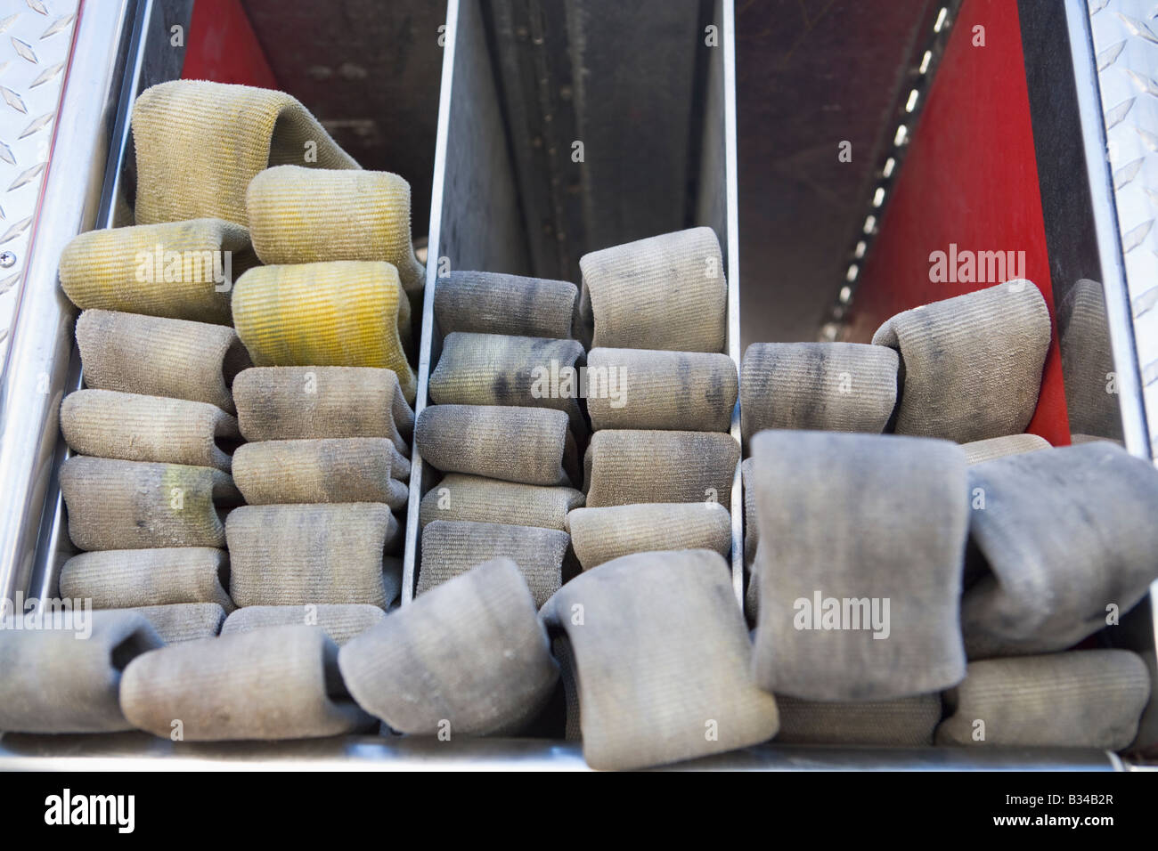 Fire hoses neatly stacked in fire engine Stock Photo