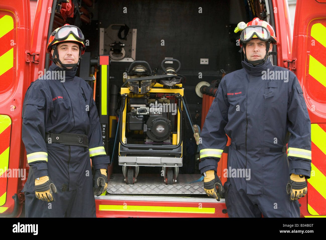 Two rescue workers standing by open back door of rescue vehicle Stock Photo