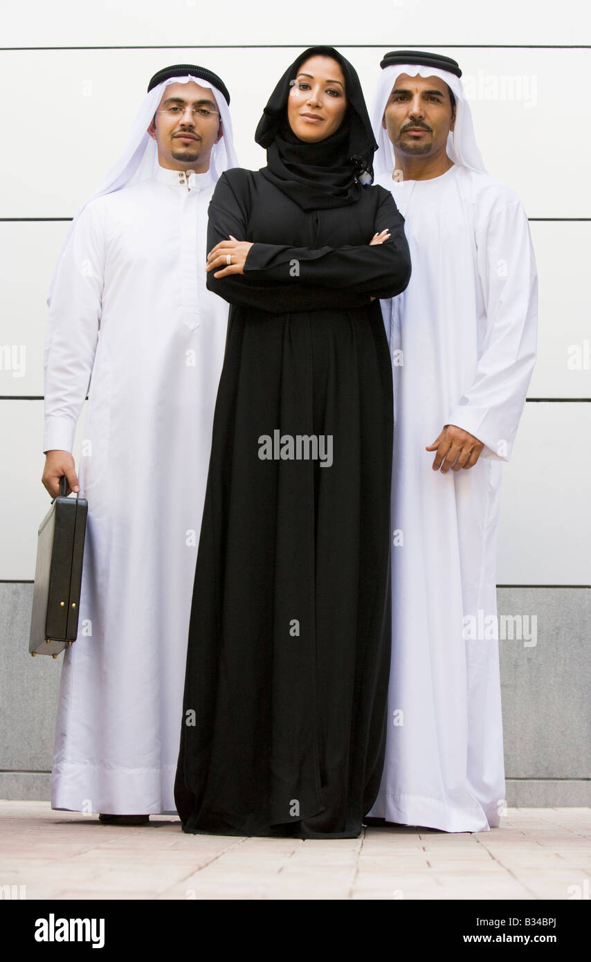 Three businesspeople standing outdoors smiling Stock Photo