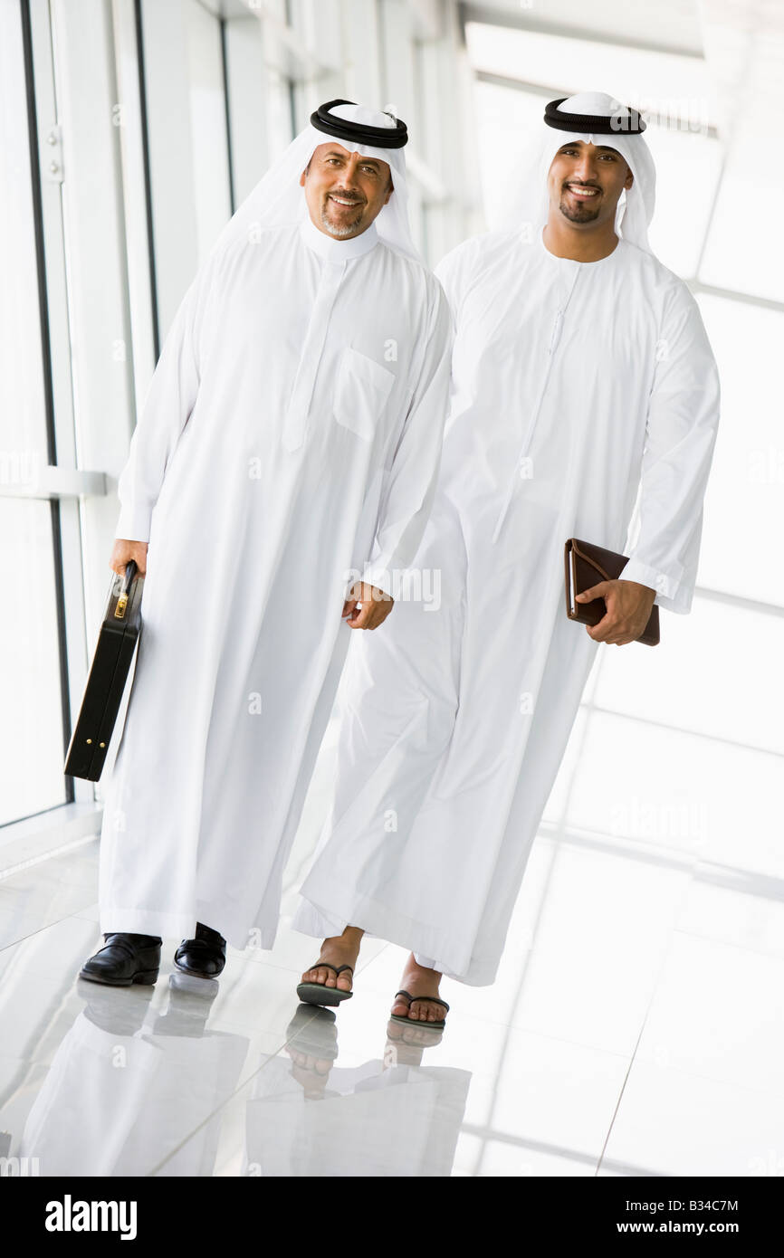 Two businessmen walking in a corridor smiling (high key/selective focus) Stock Photo