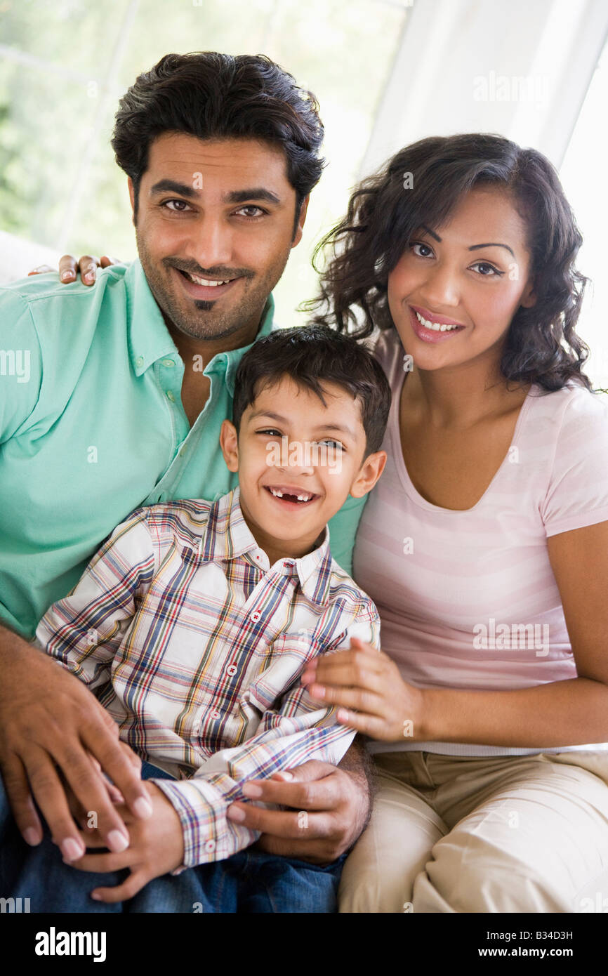 Family in living room sitting on sofa smiling (high key) Stock Photo