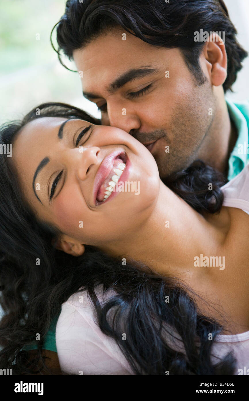 Couple in living room embracing and smiling (high key Stock Photo - Alamy